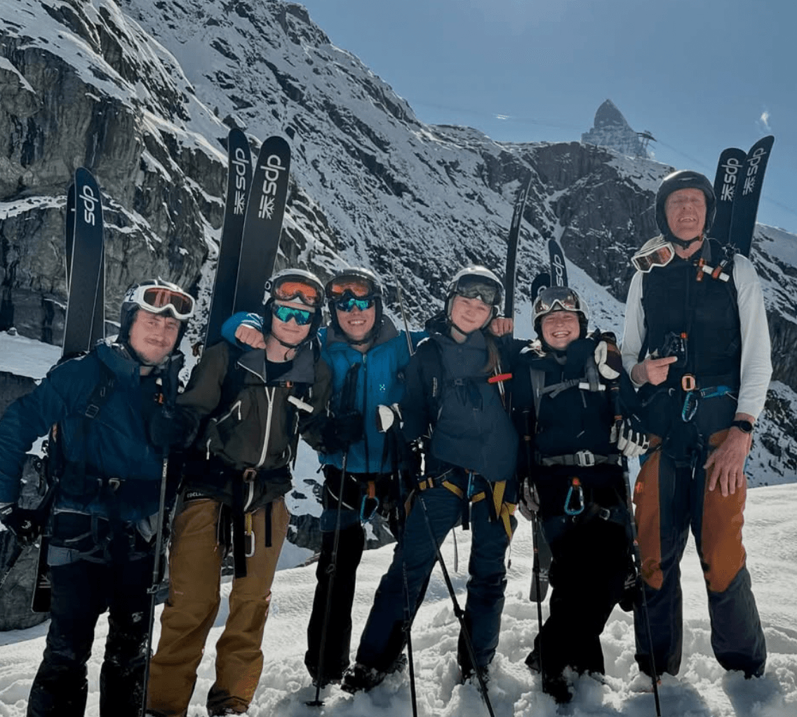 Skiers on a high ridge with the Matterhorn behind