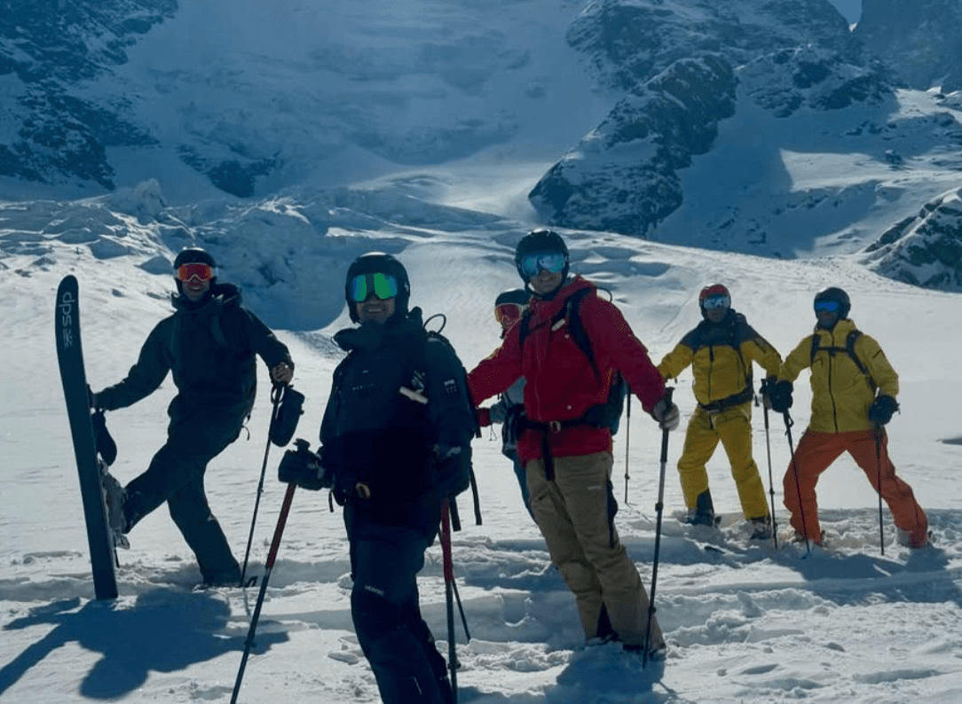 The group lined up on a snowfield below a glacier