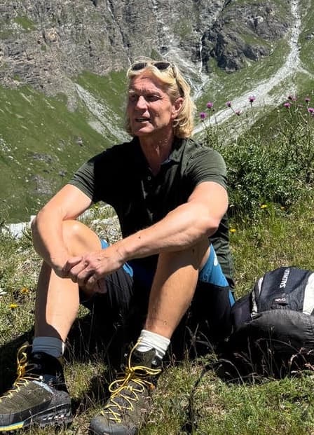 Jan sitting in an alpine meadow above the valley in summer