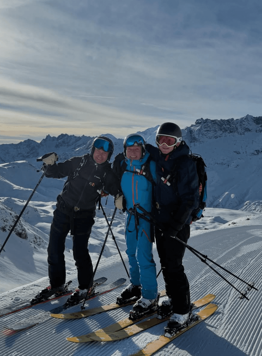 Skiers in golden evening light at the piste edge